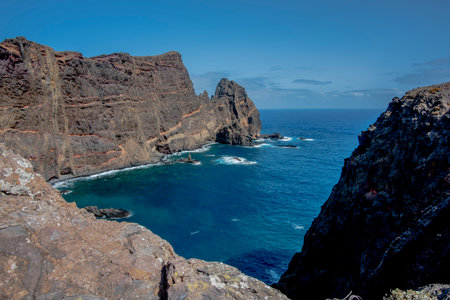 panorama of Ponta de Sao Lourenco promontory between lava mountains and sunburned meadows with waves...