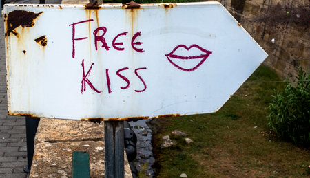white road sign with Free Kiss written and drawn lipsの写真素材