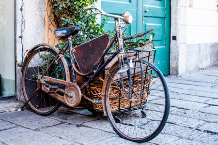 old bike ruined by time with empty sign and flowersの写真素材