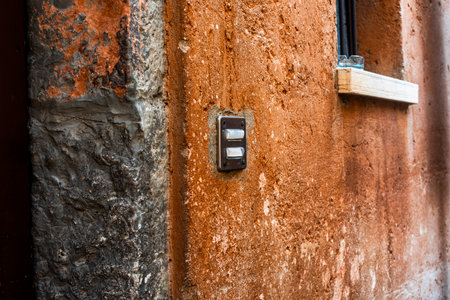 1950s vintage double doorbell on orange wall in Torri del Benaco near Lake Garda Verona Veneto Italyの写真素材