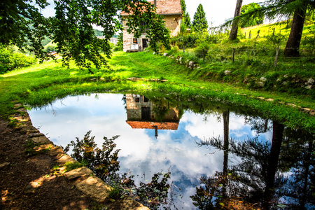 small hut in the alps reflected on the alpine lake in Tonezza del Cimone vicenza Italy Europeの写真素材