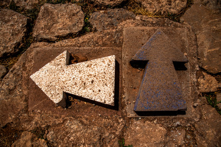 arrow carved in marble on brown ground white color direction indication maxi arrowの写真素材