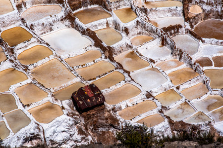 detail of the mountain salt pans with the white of the salt and the brown of the water which is turning into salt with evaporation in Peru in South Americaの写真素材