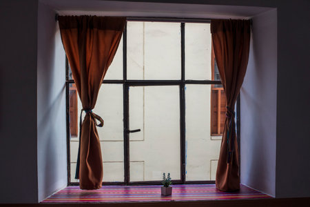 window with orange curtains in Cusco in Peru in South Americaの写真素材