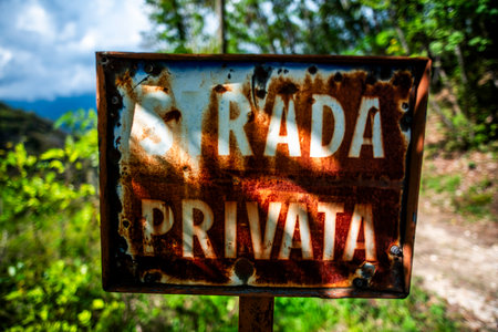 metal sign rusted by time with the words private road in the woodsの写真素材