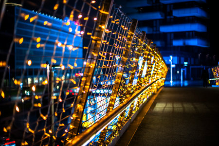 close up of small colored lights on metal mesh with yellow blue and red colors on the balustrade of...