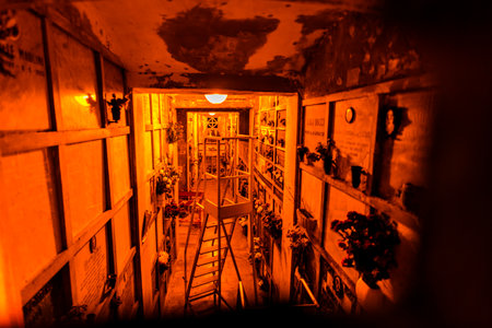 interior view of a corridor with soft yellow and orange lights inside a cemeteryの写真素材
