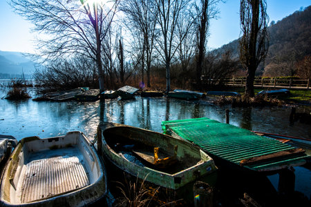 close up of parts of small fishing boats abandoned and covered with moss in the frozen waters of Lake Fimon in Vicenzaの写真素材