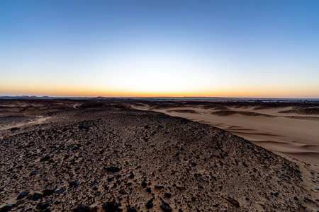 Wide rocky desert landscape near Giza Egypt at dusk with soft horizon light open sky and textured terrain conveying remoteness geological scale and a calm natural atmosphereの写真素材