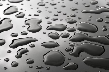 Pattern of water drops in a shining metallic surface with sky reflectionsの写真素材