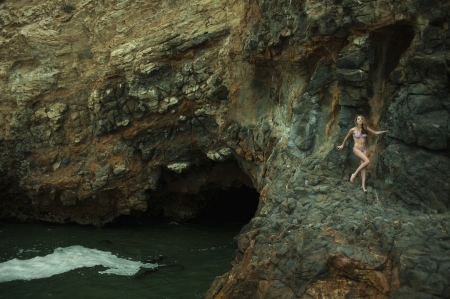 Swimsuit model posing sexy in front of black lava field on at Palos Verdes, CA の写真素材