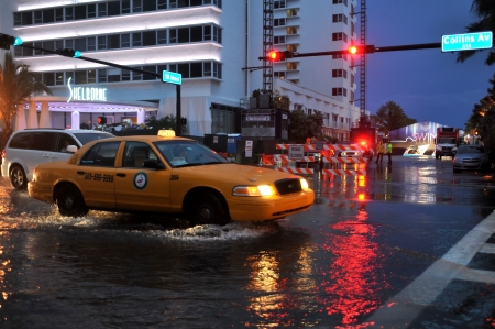 MIAMI BEACH, FL - JULY 18: Cars moving on flooded streets and roads of Miami South Beach  after heavy rains in Florida July 18, 2013 in Miami Beach, Floridaのeditorial素材
