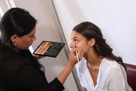NEW YORK, NY - June 16: A makeup artist applying makeup to model face backstage at the Claire Pettibone Spring 2015 Romantique Bridal collection show on June 16, 2014 in NYC.のeditorial素材