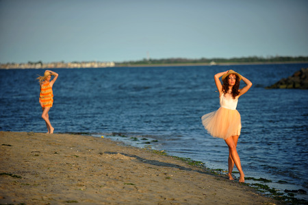 Two beautiful fashion models enjoy the beach during the summer time.の写真素材