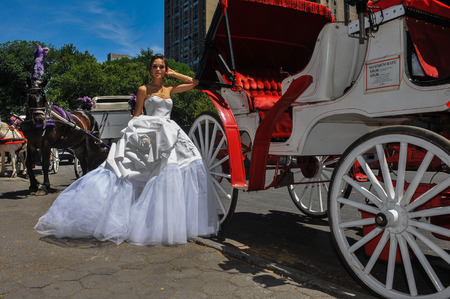 NEW YORK - June 13: Model Kalyn Hemphill pose in front of horse carriage at the Irina Shabayeva SS 2016 Bridal collection photoshoot on June 13, 2015 in New York, USAのeditorial素材