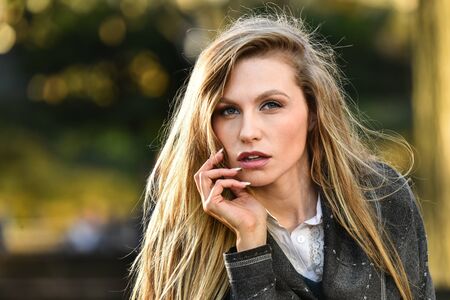 Beautiful sexy blonde model posing in the autumn park. Beauty close up portrait.の写真素材