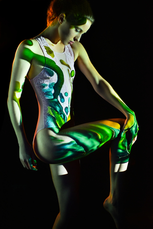 Fashion, creative photo, woman with color image on her face and body. Image projection.の写真素材