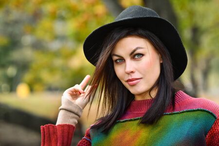 Portrait of  beautiful brunette woman at the autumn park.