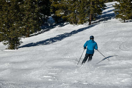 A man skiing down. View to the mountains from the top angle. Sunny day at Vail Ski resort, Colorado, USAの写真素材