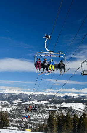 People riding ski chair lift at Breckenridge, Coloradoの写真素材
