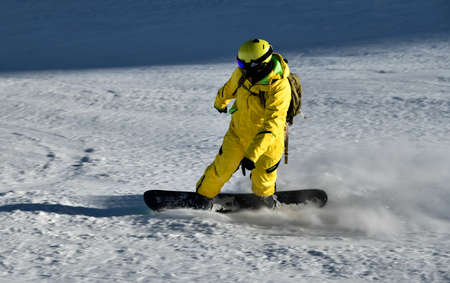 Man wearing yellow suit snowboarding down at extreame double diamond area at Emperial bowl .Extreme winter sports. Action shot. Breckenridge, COの写真素材