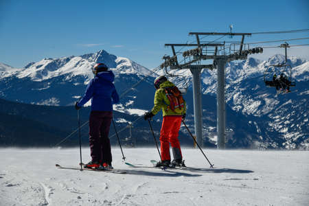 Skiers overlooking to the panoramic view of Vail ski resort in winter time in the Colorado Rocky Mountainsの写真素材