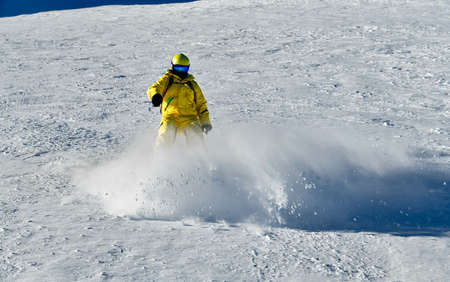 Man wearing yellow suit snowboarding down at extreame double diamond area at Emperial bowl .Extreme winter sports. Action shot. Breckenridge, COの写真素材