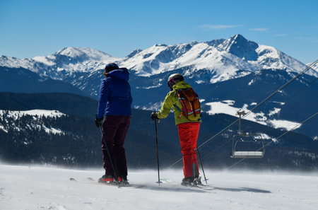 Skiers overlooking to the panoramic view of Vail ski resort in winter time in the Colorado Rocky Mountainsの写真素材