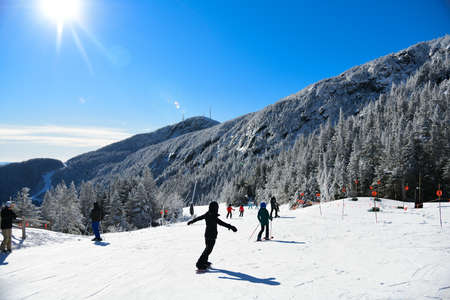 Amazing sunny day at Ski Mountain Resort. People enjoy skiing and snowboarding.の写真素材