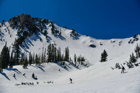 Skiing and snowboarding at Snowbasin Ski Resort in Utah. Active lifestyle and winter vacation in...