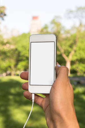 Men in the park with white phon in hand 