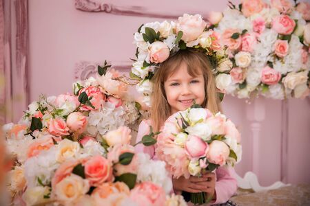 Nice girl with flowers. Baby with a flower bouquet for his birthday or for his mother 's day.の写真素材