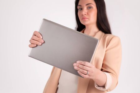 Successful business woman on grey background with copy space laptop mock up, blank