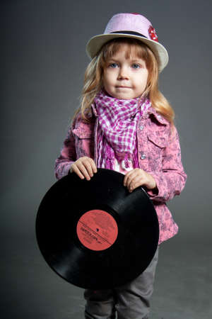 Little girl in hat holds vinyl disc recordのeditorial素材