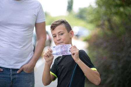 Cute teenager boy with money euro in handの写真素材