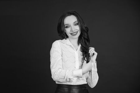 Portrait of a business woman, happy and smiling as she looks at the camera. black background. Concept of: success, finance and female career. Black and white photoの写真素材