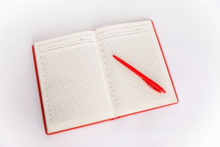 Red leather daily planner with a Red pen isolated on white background