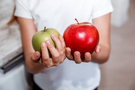 child in the kitchen holding a fresh apple. Organic natural healthy foodの写真素材