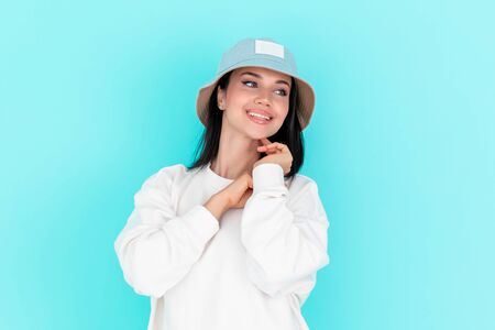 Fashion girl in blank sweatshirt jacket in summer hats on a blue background. Copy space