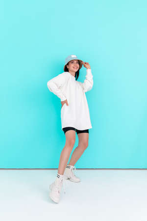 Fashion girl in blank sweatshirt jacket in summer hats on a blue background. Copy space