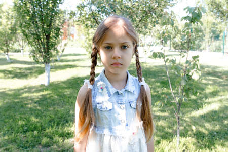 sad portrait of a little cute girl. girl with pigtailsの写真素材