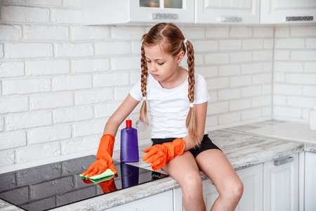 Cleaning the oven concept. little girl cleans kitchen stove.の写真素材
