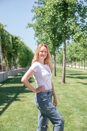 summer. a Russian girl in jeans and a T-shirt with long white hair walks around a green park. Krasnodar Parkの写真素材