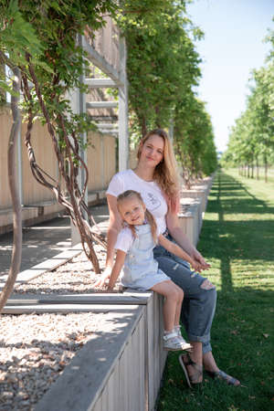 Beautiful mother and little daughter walking together in summer park. Krasnodar Parkの写真素材