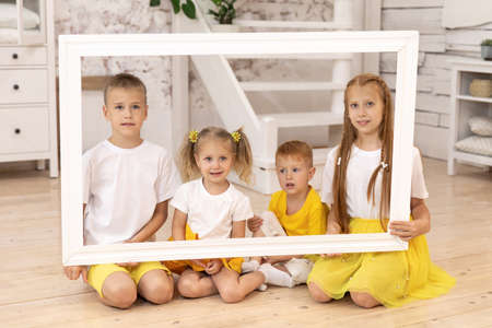 Smiling children holding picture frame. four children. brothers and sisters