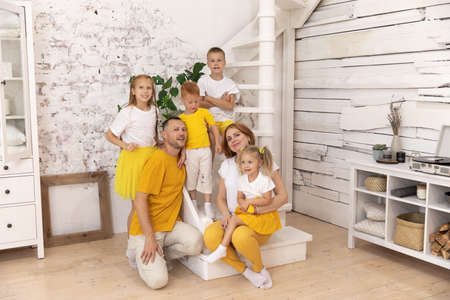 the whole family is wearing white and yellow T-shirts. parents and children have a great time togetherの写真素材