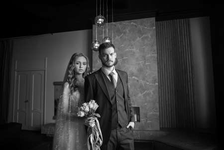 beautiful young couple. groom and bride. a modern wedding. dark interior.の写真素材