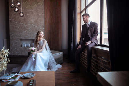 beautiful young couple. groom and bride. a modern wedding. dark interior.の写真素材