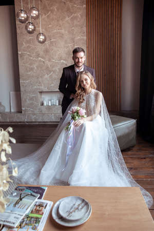 beautiful young couple. groom and bride. a modern wedding. dark interior.の写真素材
