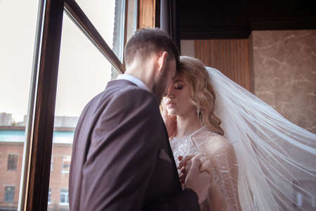 beautiful young couple. groom and bride. a modern wedding. dark interior.の写真素材